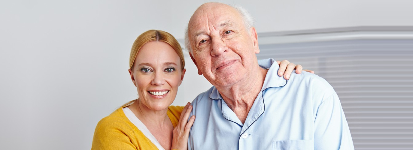 female caregiver and senior man smiling indoor