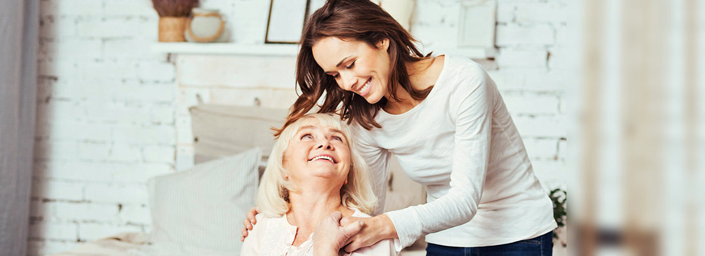 caregiver hugging senior woman